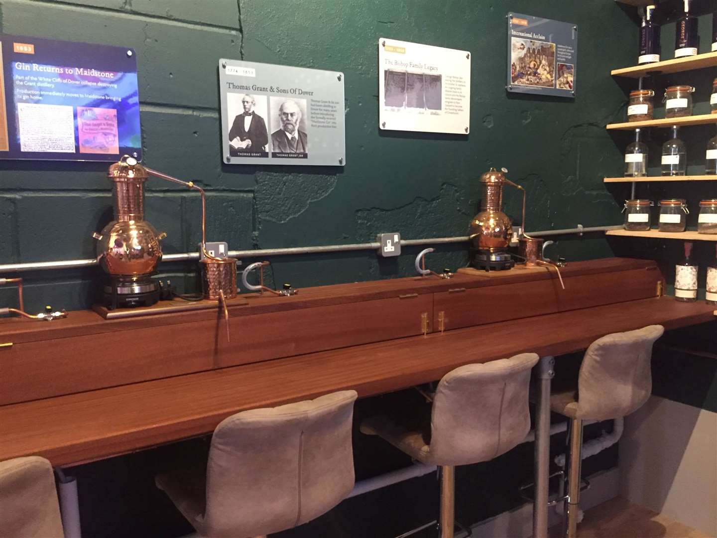 Mini copper stills sit upon the benches in the experience room