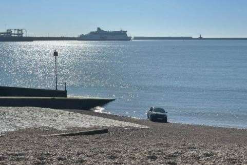 A car is in the sea along Dover beach this morning. Police are at the scene. Photo: LKJMEDIA