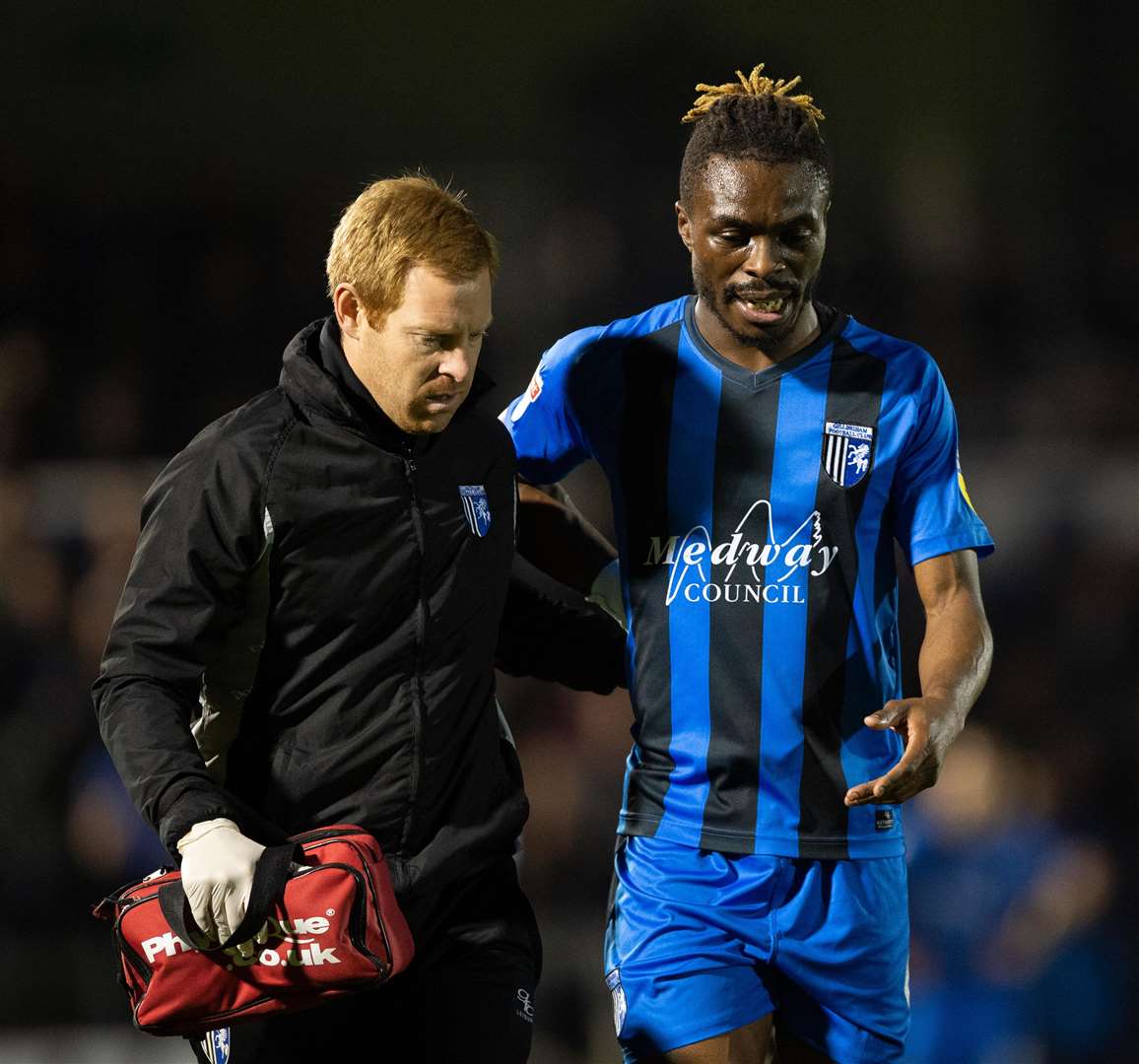 Gillingham defender Gabriel Zakuani helped off the pitch at Bristol Rovers by physio Gary Hemens Picture: Ady Kerry