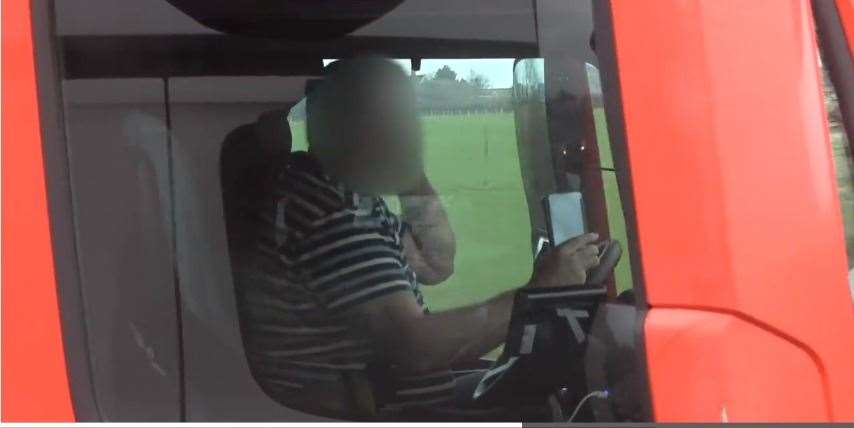 An HGV driver pictured with a mobile phone in each hand while travelling on the M4. Picture: National Highways