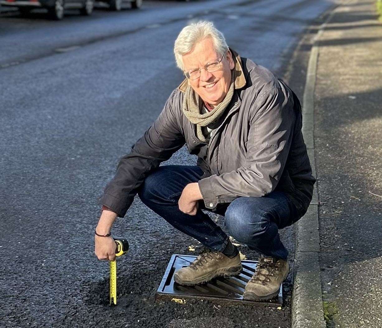 Campaigner David Ward measures a pothole in Tenterden
