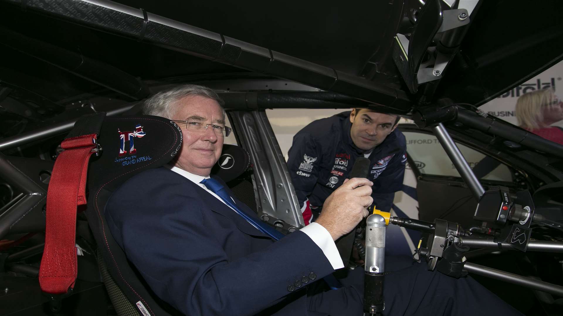 Mr Fallon sits in a racing car at Brands Hatch circuit
