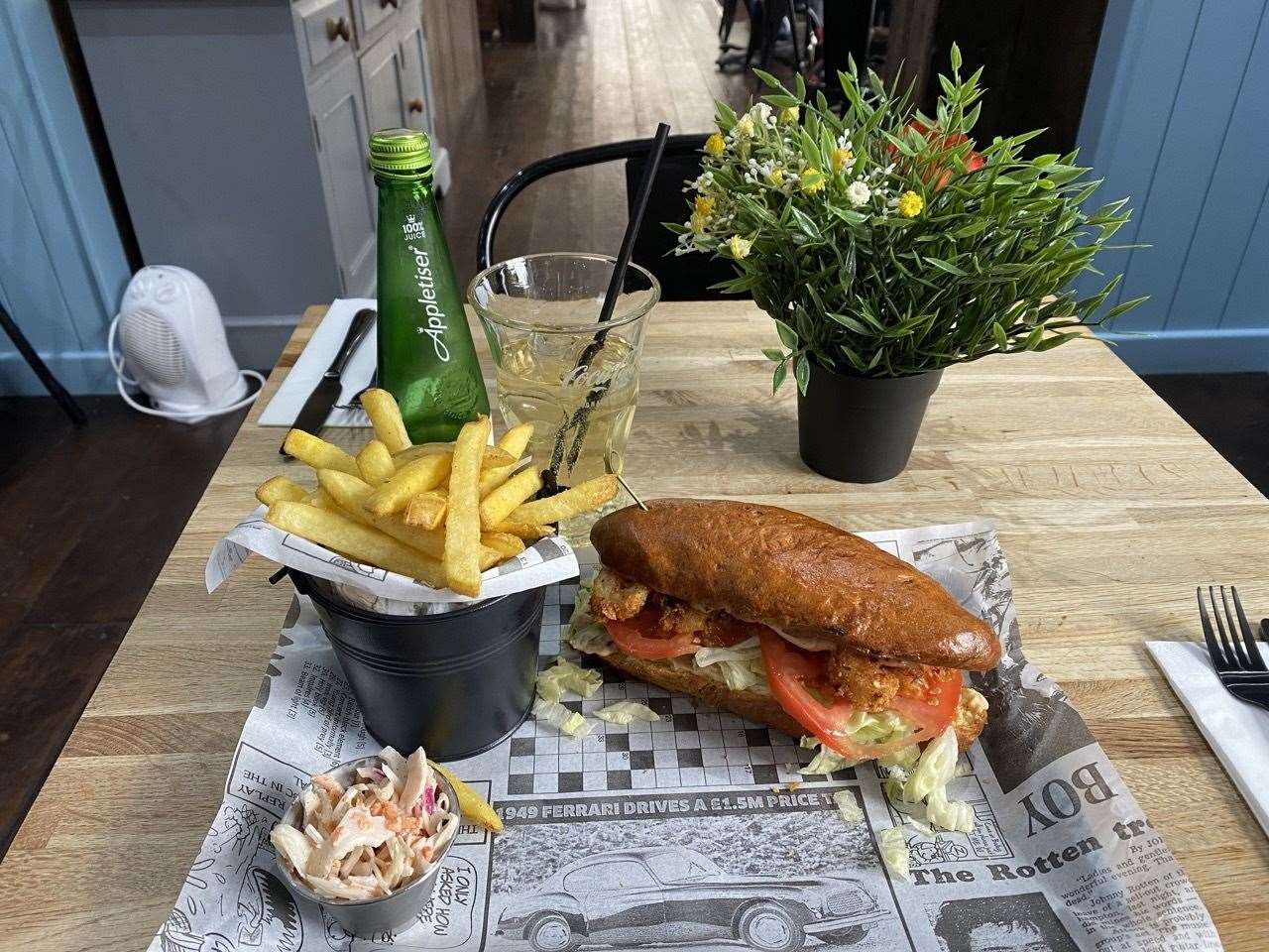 A tasty sandwich, chips, salad and a drink made for a delightful lunch
