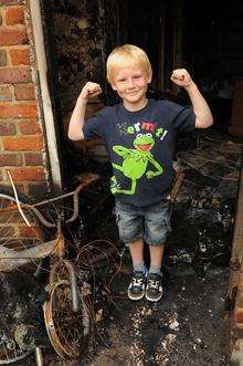 Dane Tolhurst-Young by the fire damage at the family home in Dartford