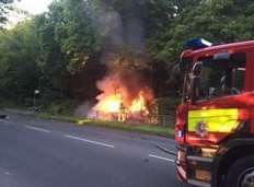 Firefighters tackle the burning car