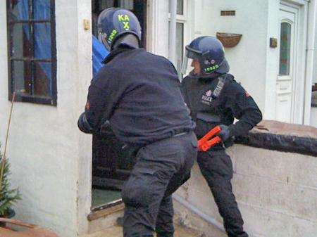 Police break down a door on one of the drug raids