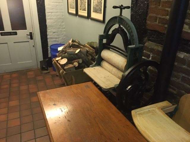 The hallway to the toilets and the public bar is tastefully decorated and used to store logs, a high chair and a superb old mangle
