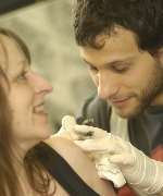 Sue Mitcheson undergoing the tattooist's needle for hubby Ian