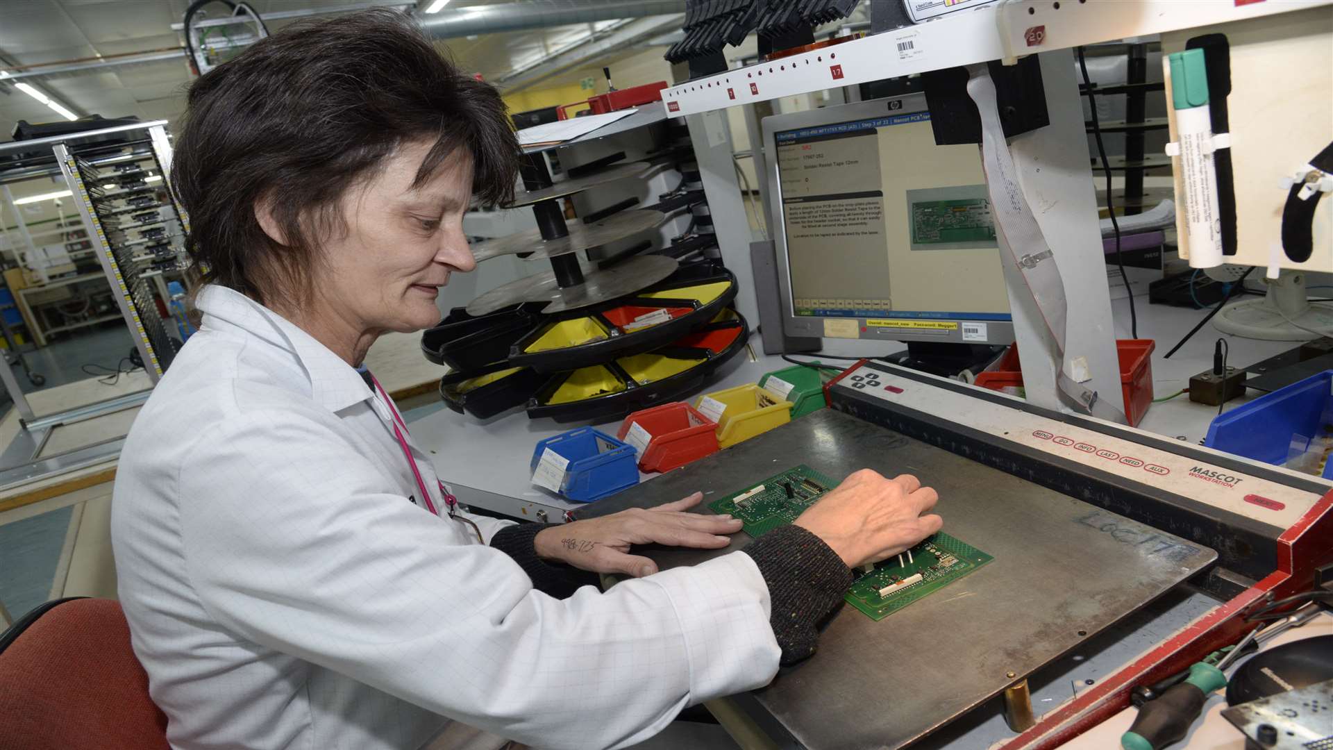 Deana McCarthy assembles a circuit board at Megger's factory, which is celebrating 50 years