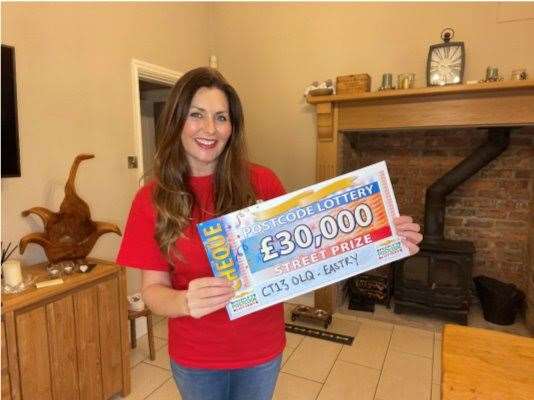 Postcode Lottery ambassador Judie McCourt with the cheque for £30K won by each of the three Eastry neighbours