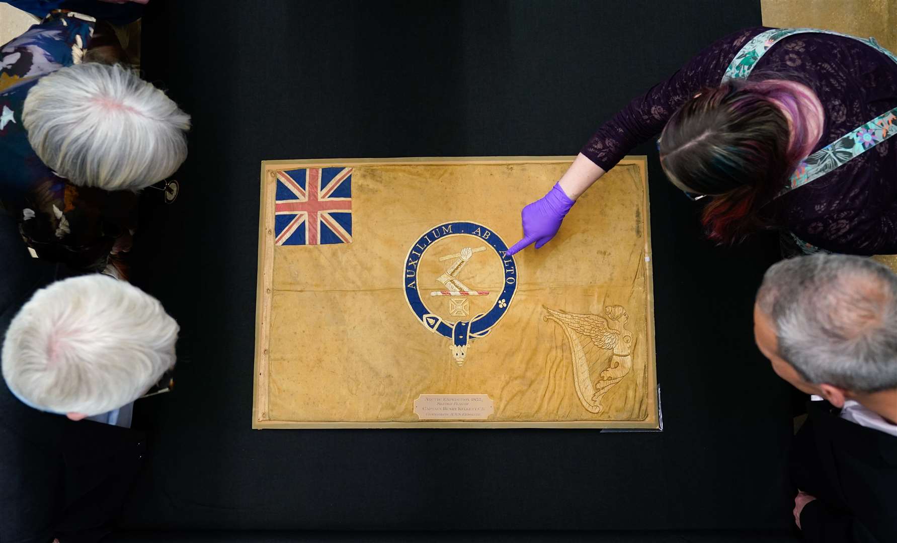A conservator from the National Museum of the Royal Navy with the Kellet Sledge flag after it was taken out of it’s frame for inspection at Portsmouth Historic Dockyard in Hampshire. (Andrew Matthews, PA)