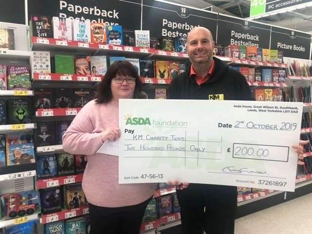 Asda Canterbury community champion Teresa Gower with a £200 cheque for Buster’s Book Club and Dominic Comins of the KM Charity Team (19042082)
