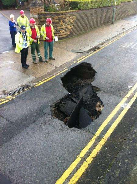 Workmen fix a hole in Hill's Terrace, Chatham, caused by a burst water main.