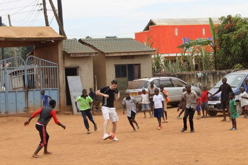 A staff member from Parenta plays football with local school children