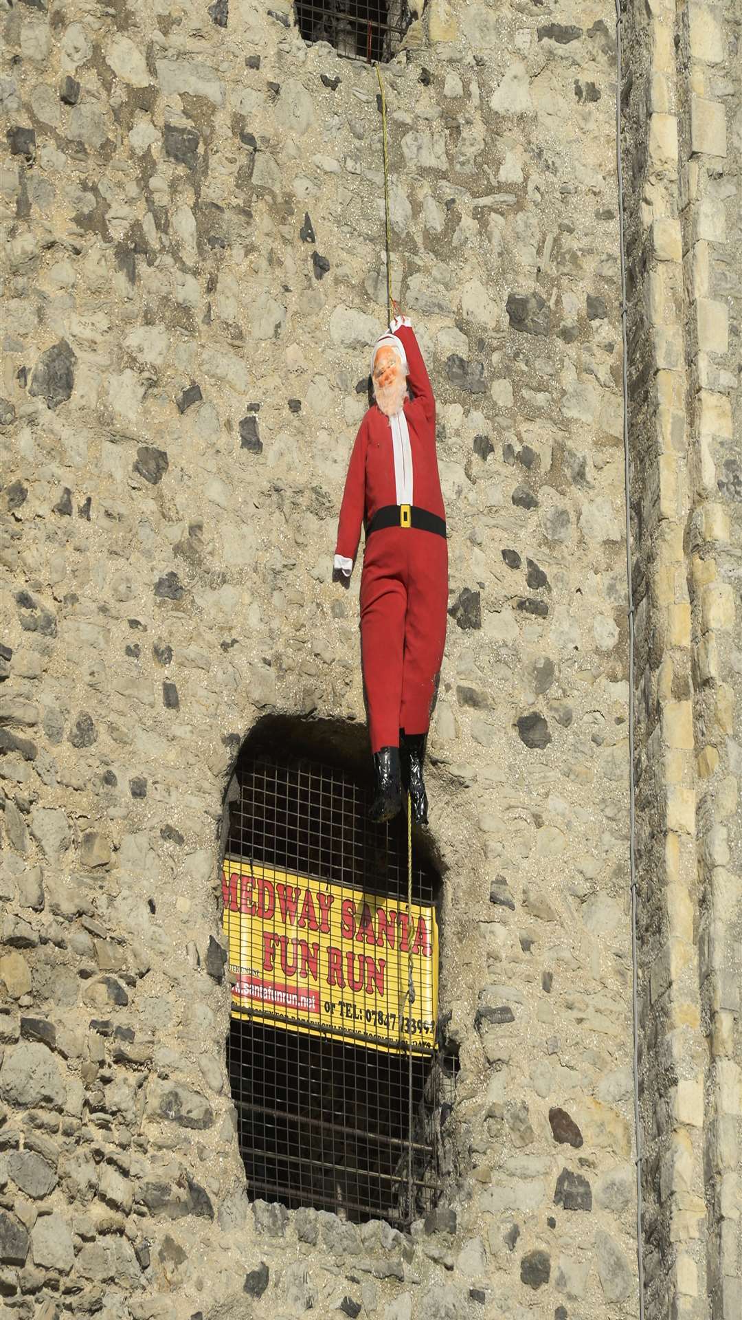 Santa Claus is suspended 70 feet in the air from Rochester Castle