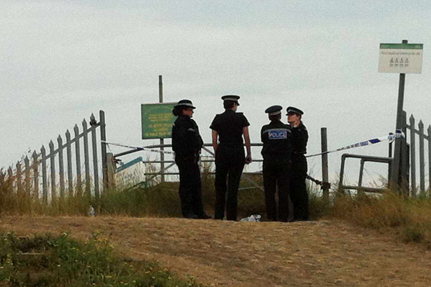 Police officers guard the entrance to a beach where Gary Pocock was found dead