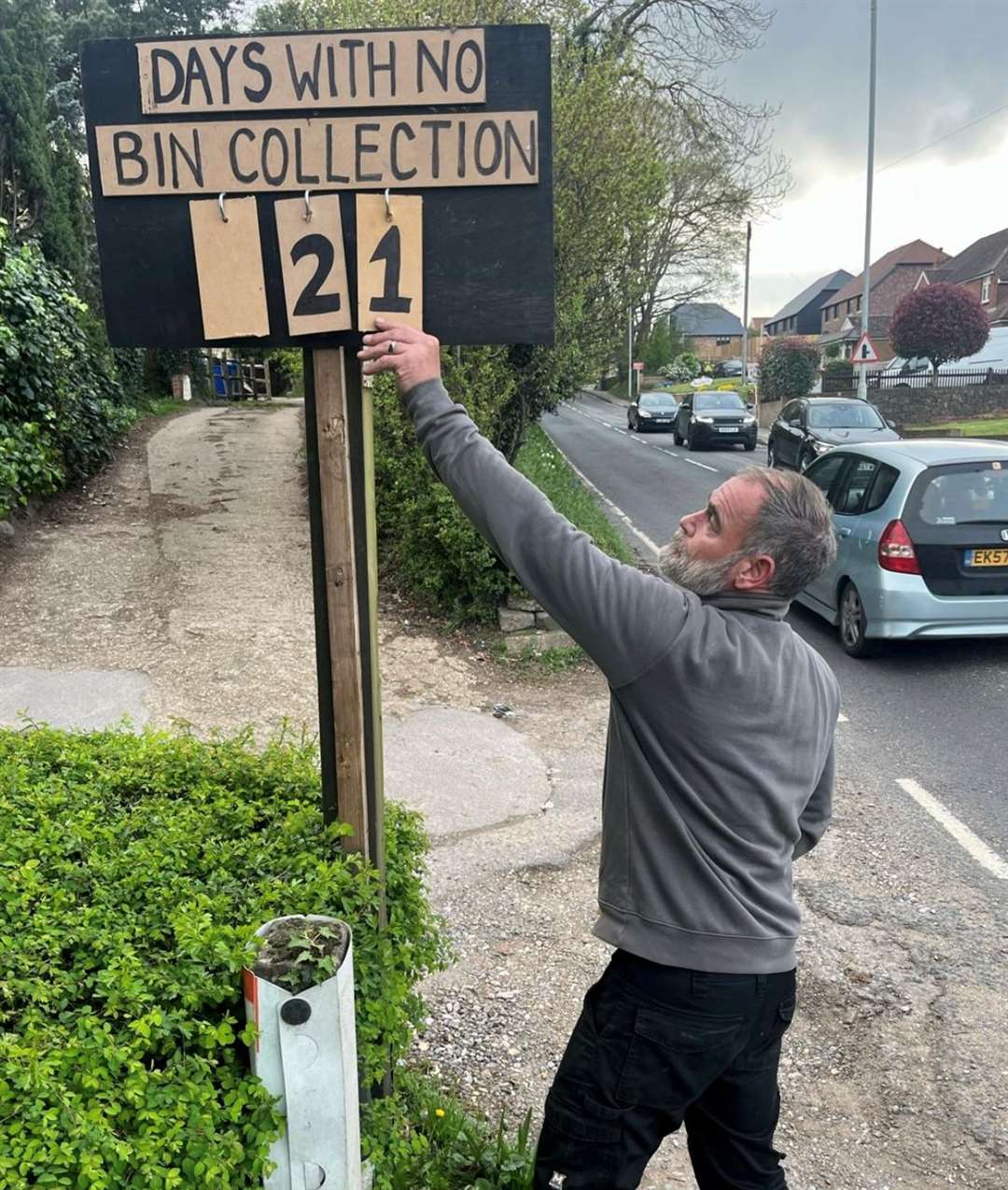 Andy Duffus with his sign tallying how many days since the last bin collection. Picture: Becci Duffus