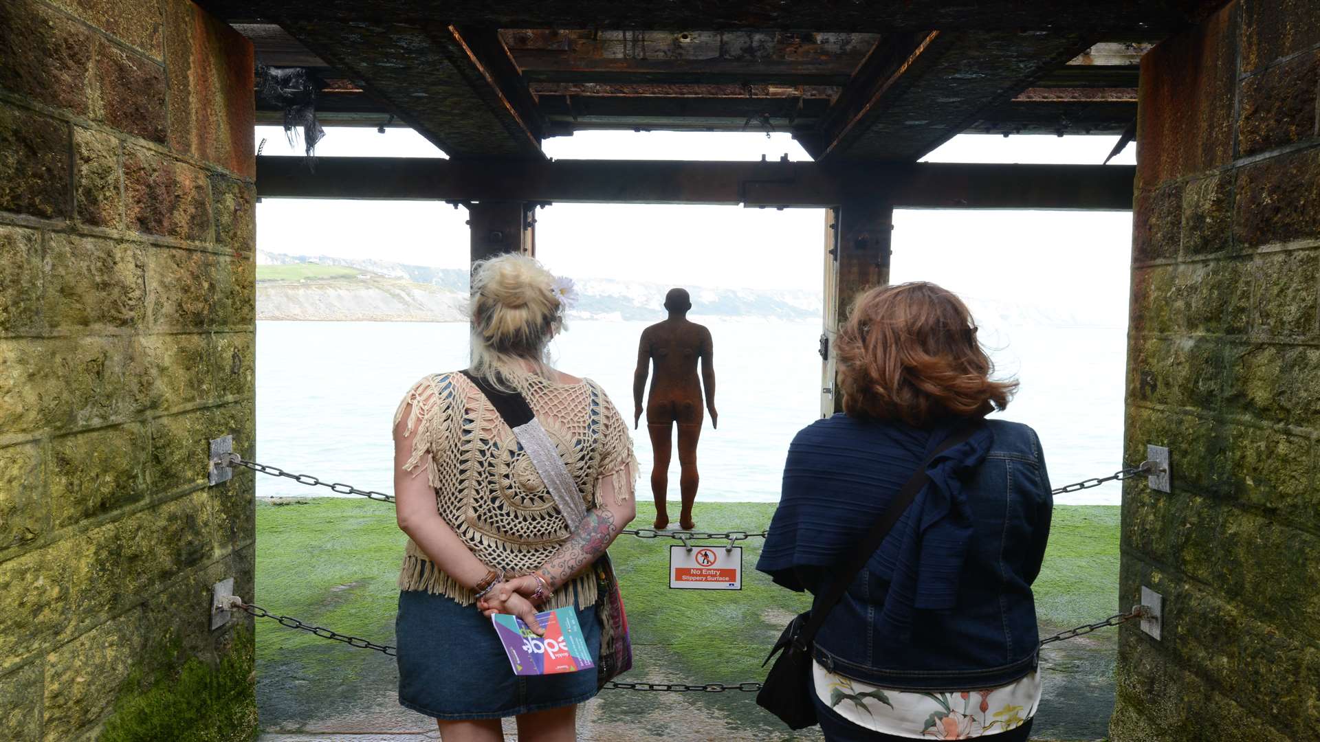 Art buffs checking out Antony Gormley's work at the Harbour Arm in Folketone Picture: Gary Browne