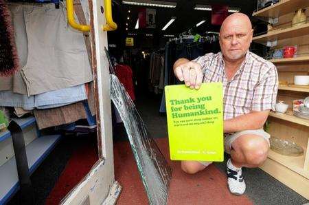 HOW COULD THEY? Mick Constable, manager of the Oxfam shop in Sheerness, with a shop sign in sad contrast to the behaviour of the thieves