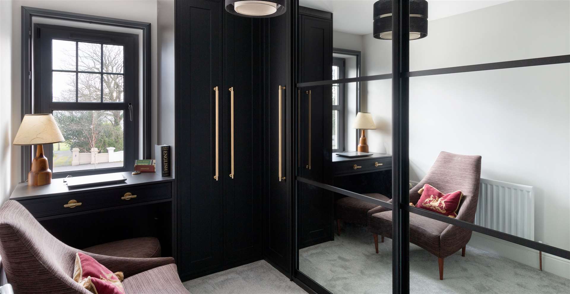 Black framed sliding mirror with slim hinged wardrobe and custom-built desk
