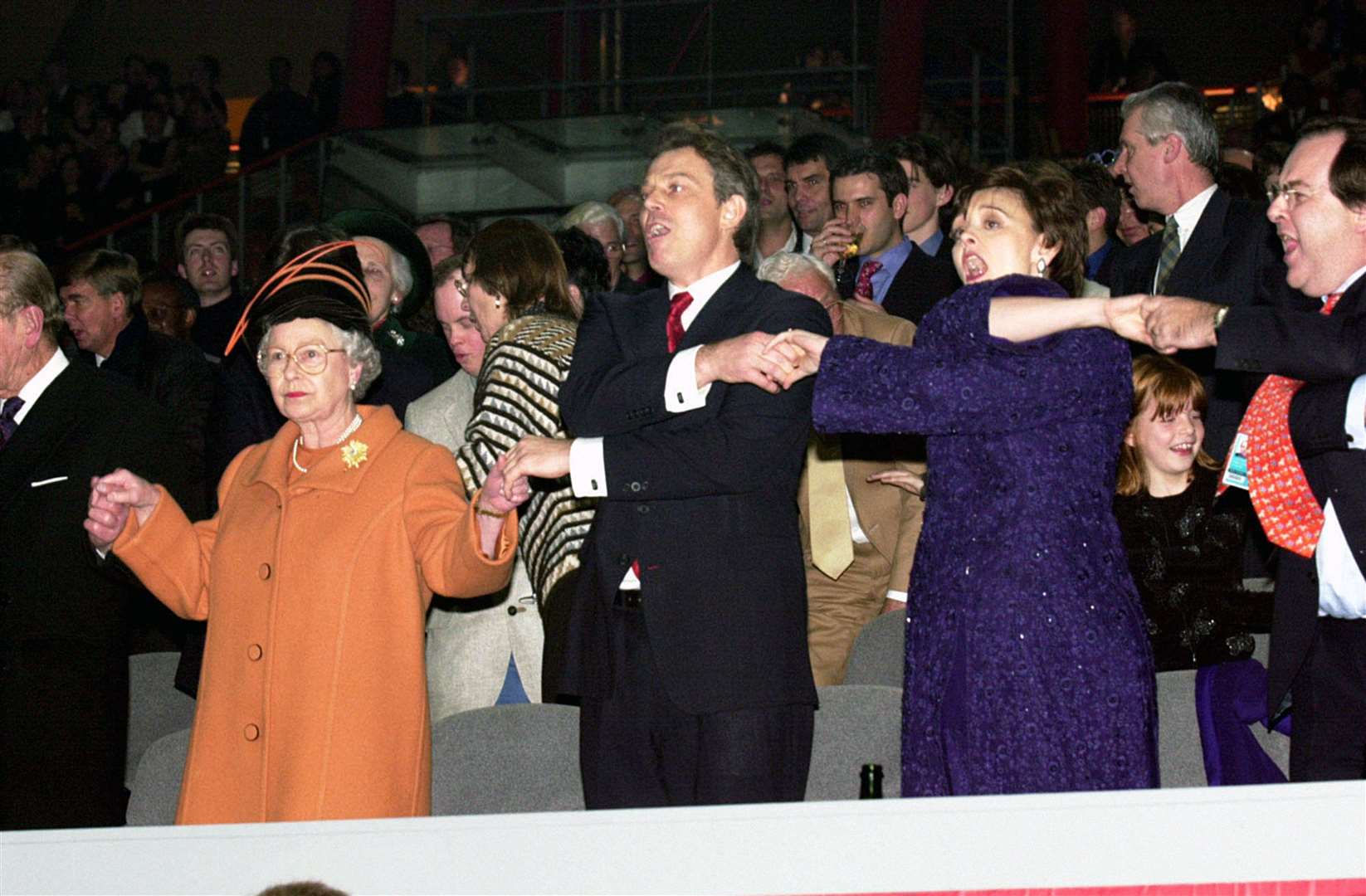 The Queen joins Tony Blair and wife Cherie as they sing Auld Lang Syne in the Millennium Dome to mark the start of 2000 (PA)