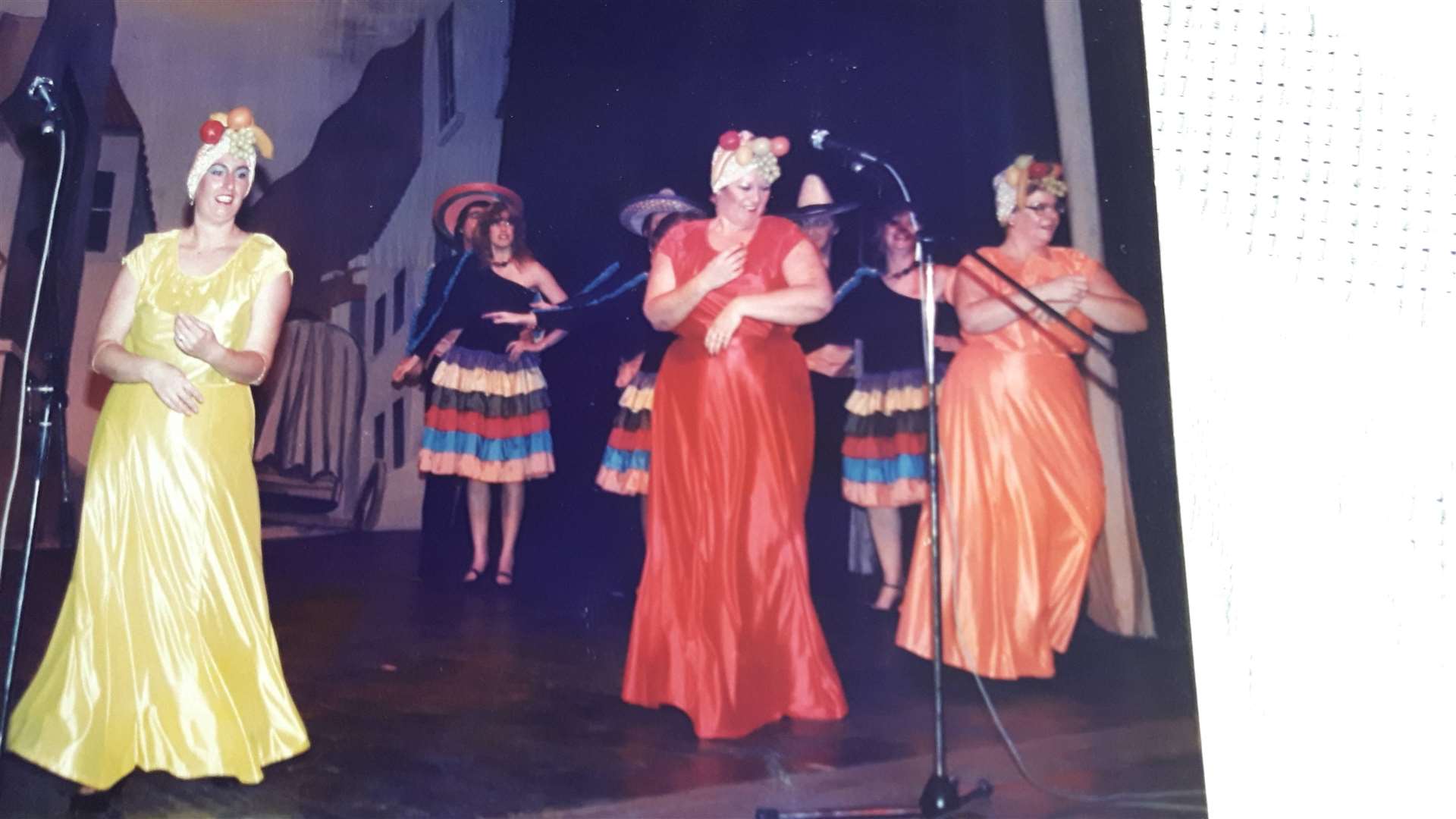 A scene from Brazil with Angela Waller in the red dress and Chrissie Sandell in the orange in 1987