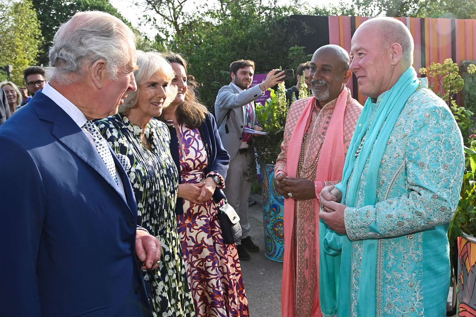 The King and Queen speak with Manoj Malde, an ambassador for inclusivity, and Clive Gillmor following their traditional Hindu ceremony marriage in the Eastern Eye Garden of Unity at Chelsea last year (Toby Melville/PA)