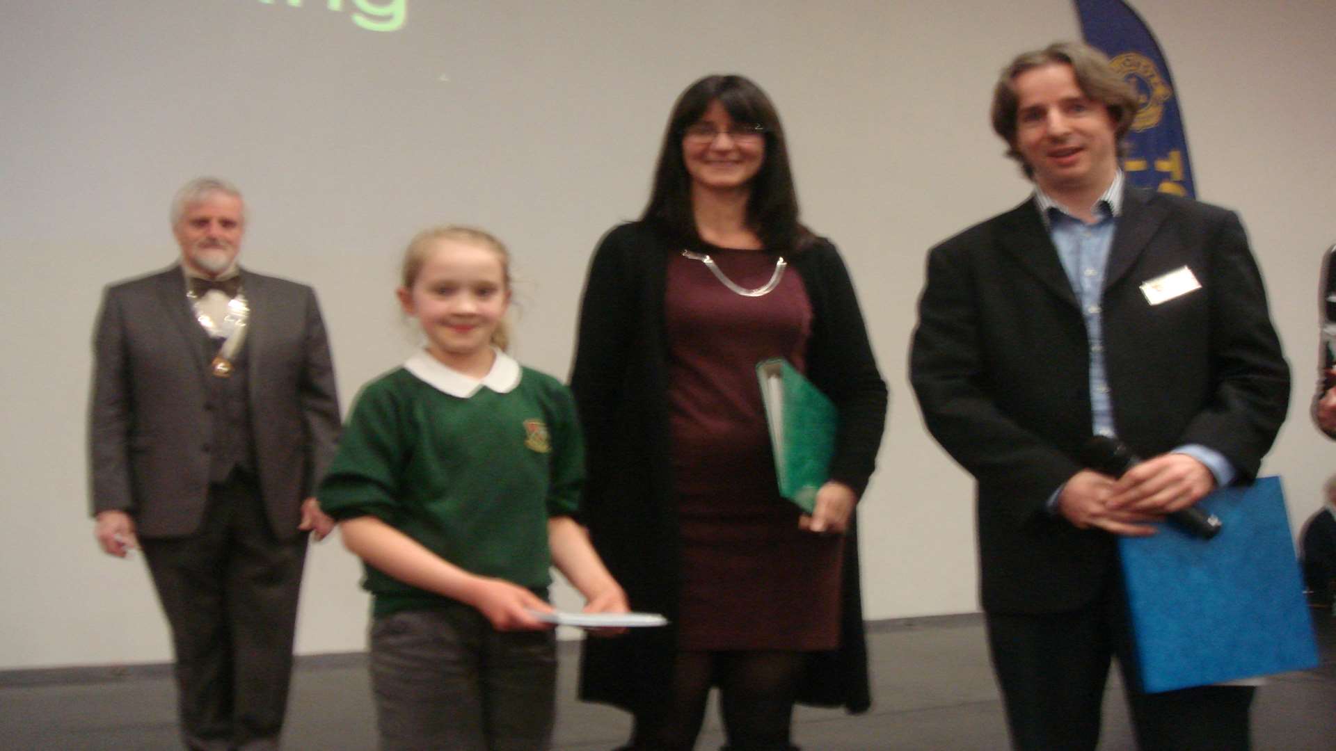 One of the choir from Slade School collects the first prize from the judges