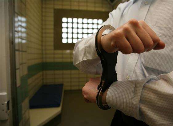 Man handcuffed in police cells. Stock image