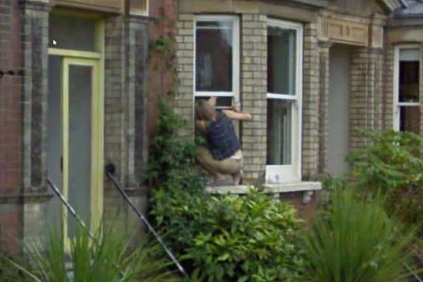 The Google Street View image of a woman climbing through a window in Faversham