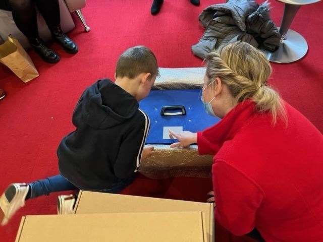 Ronnie Hawkings at Demelza, Sittingbourne, unboxing the cuddle cot he raised money for