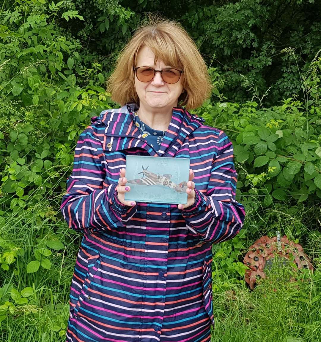Cllr Jackie Bennett holding a piece of memorabilia which has been left at the memorial for Mr Blumer in Nettlestead Green