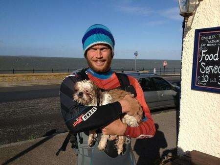Water sports instructor Charlie Head with a dog he pulled from the waves off Hampton