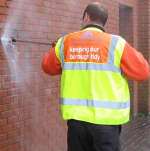 A member of Swale council's graffiti team blasts a wall clean