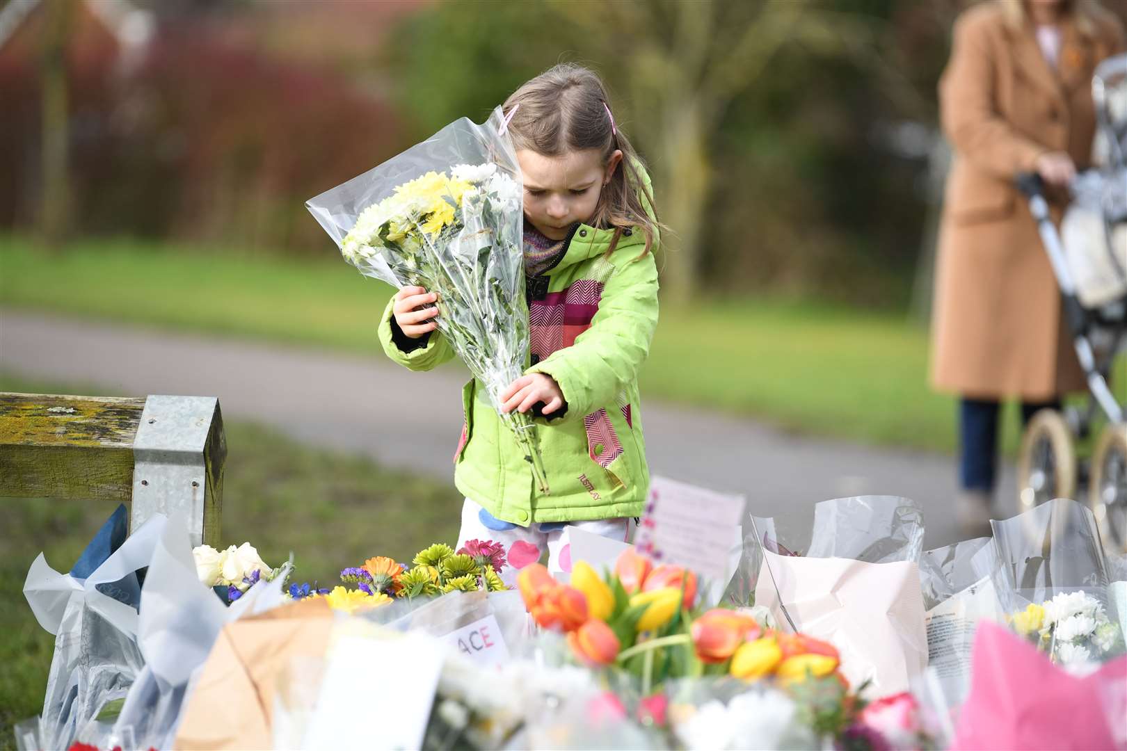 Noelle Simmons, four, leaves a floral tribute outside the home of Captain Sir Tom Moore in Marston Moretaine, Bedfordshire (Kirsty O’Connor/PA)