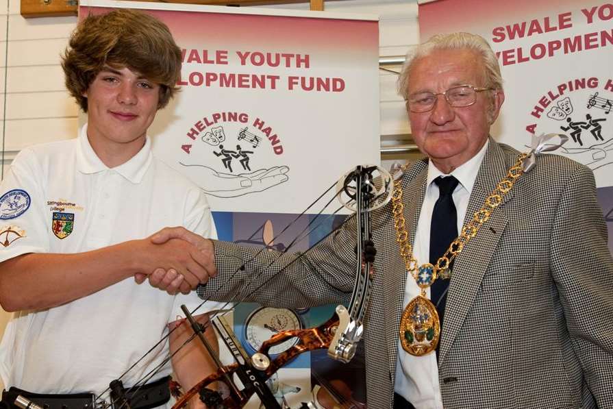 Mayor Cllr George Bobbin presents a compound bow to Charlie Collis