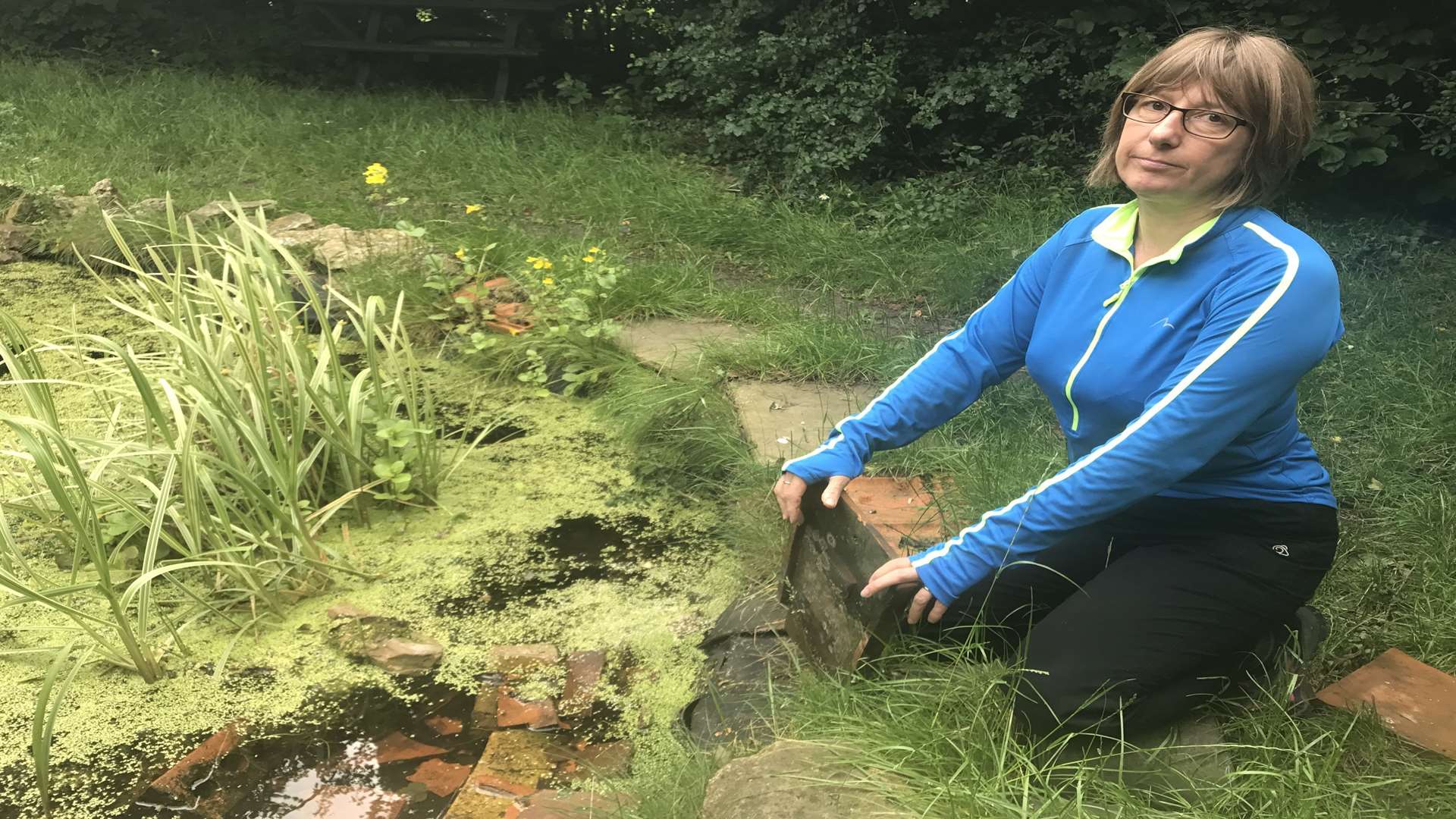 Green Zone co-ordinator Anne Collins with tiles which had been smashed in the pond