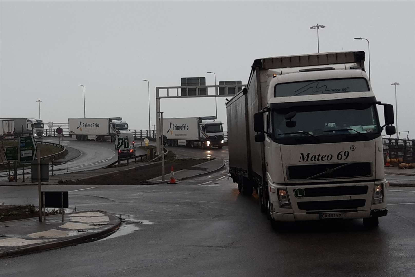 A line of trucks move towards the docks
