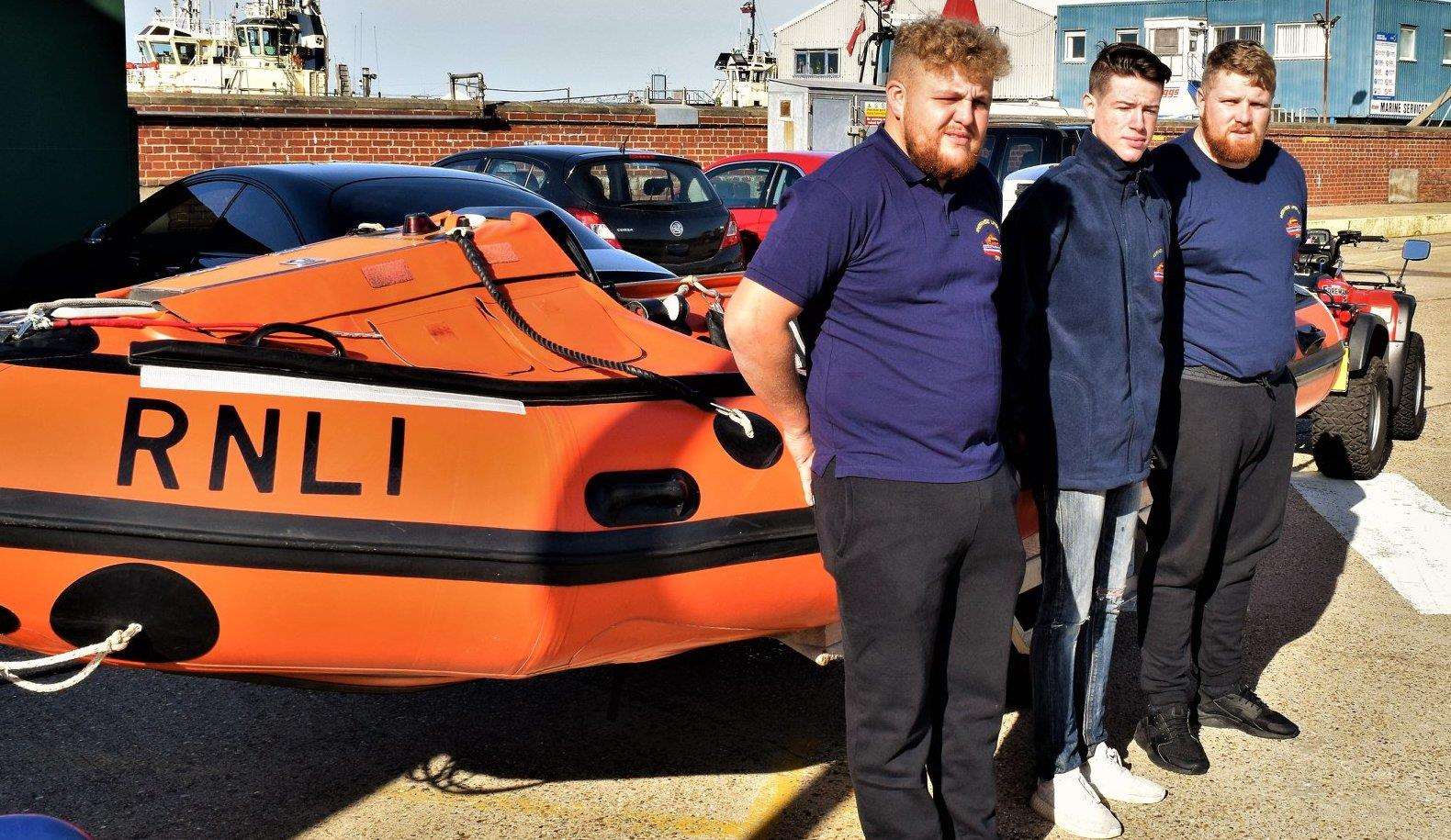 Logan Enfield, centre, meets RNLI crew members Jason Strudwick and Luke Harris who were the duty crew along with helmsman Clive Hancock on the day of his accident
