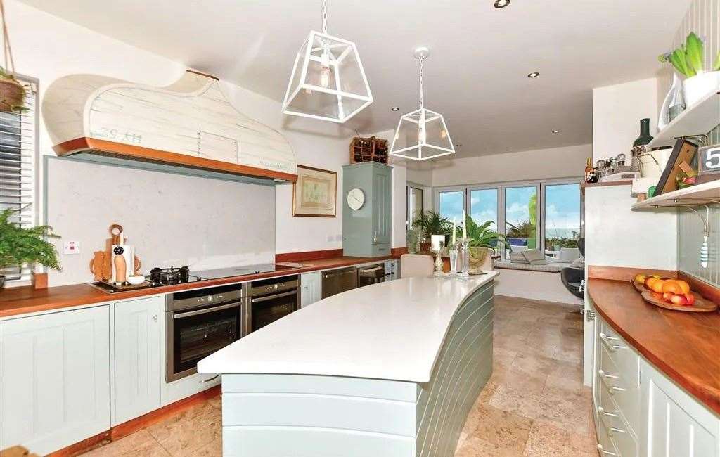 The bespoke kitchen features a shark fin-shaped breakfast bar. Picture: Fine and Country