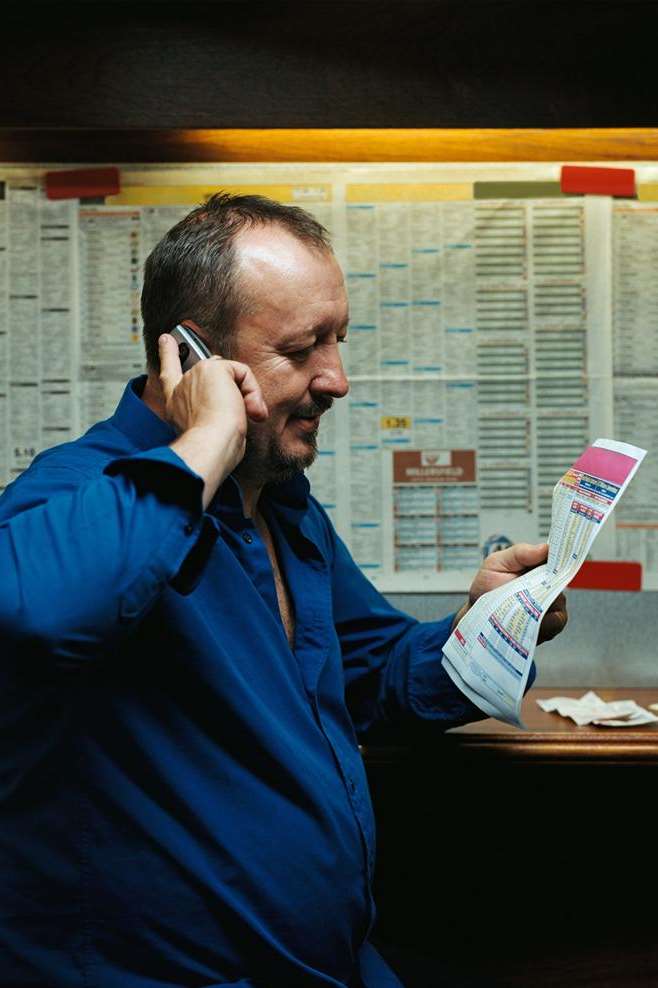 A man on the phone in a betting shop. Copyright: Thinkstock Image Library
