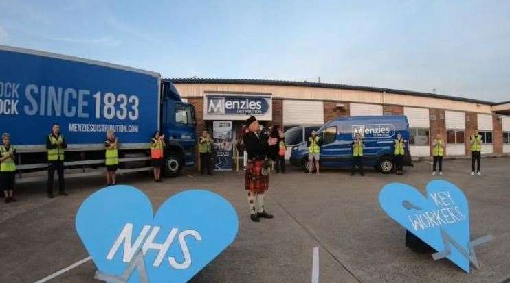 A piper plays at Menzies Distribution in Aylesford, near Maidstone, as staff pay tribute to NHS staff and other key workers during the coronavirus pandemic