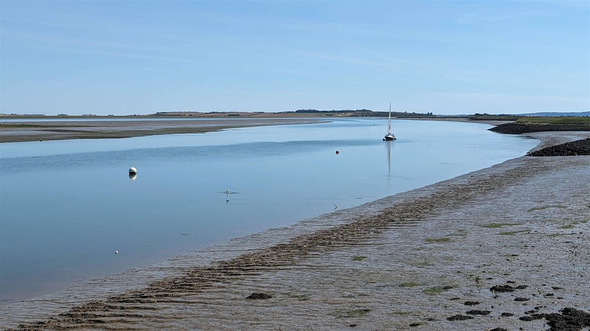 A sail boat plots a path through the Swale channel