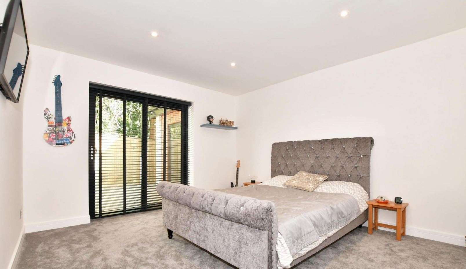 The guest bedroom features an en-suite and sliding glass door. Picture: Fine and Country