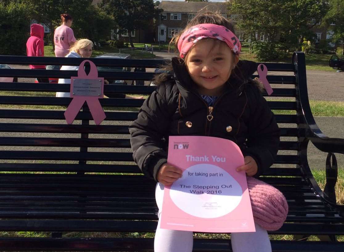 Aaliyah Rose Behan holds her certificate on Julie's Bench