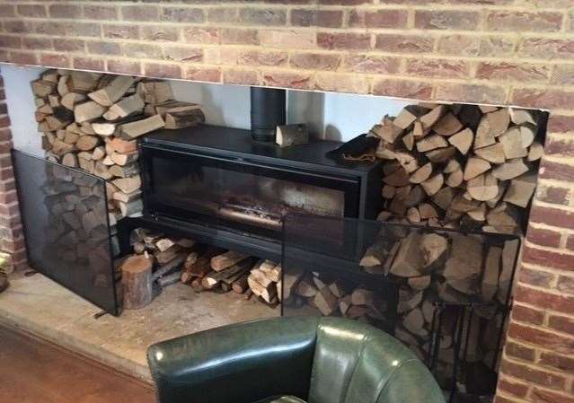 This monster log burner has been installed and is surrounded by a substantial supply of fuel – it must produce a healthy amount of heat when it is fired up