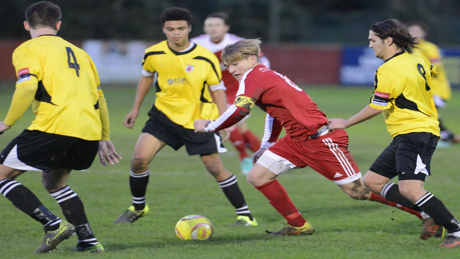 Hythe captain James Morrish takes on three Faversham players Picture: Gary Browne