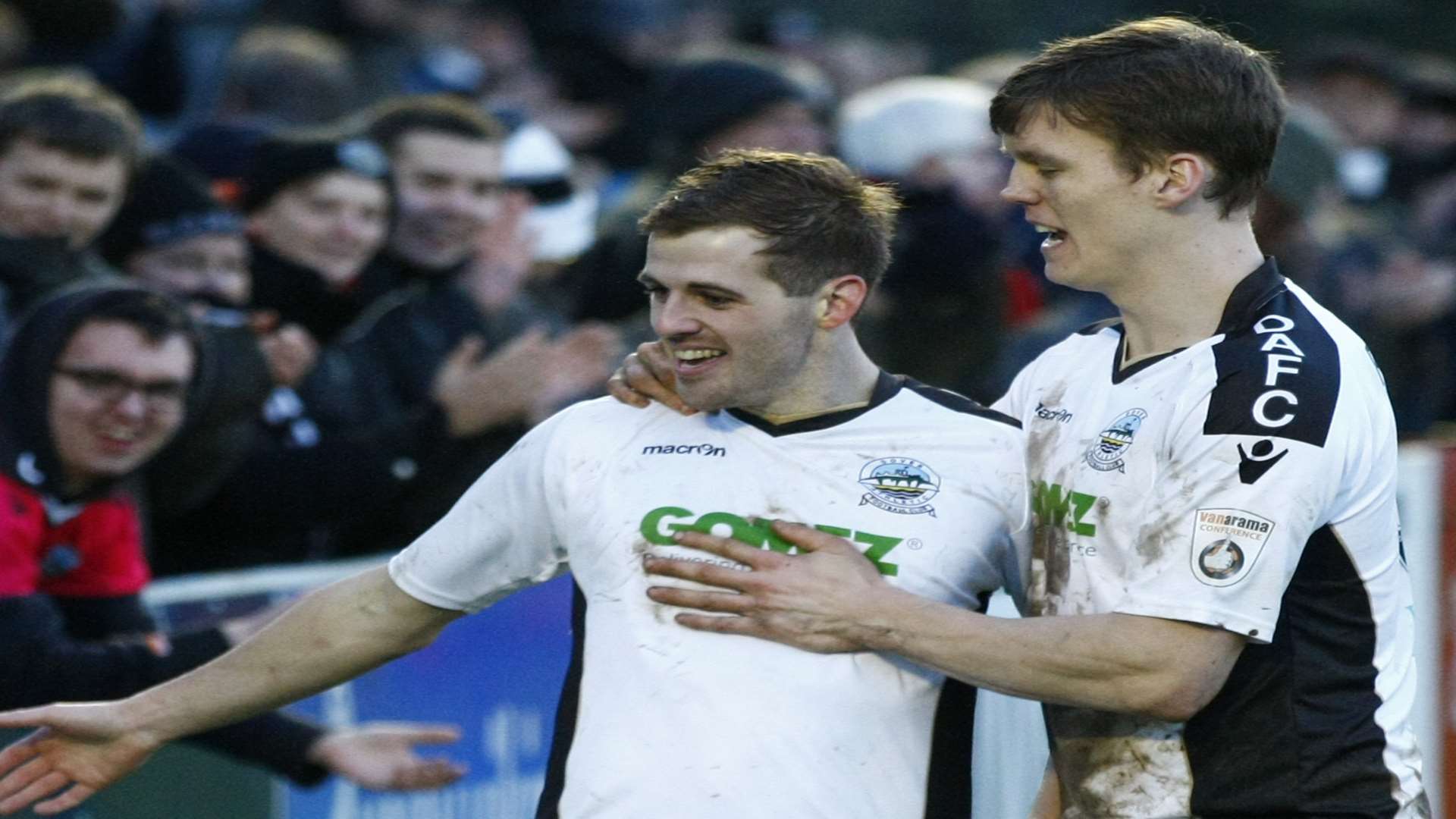 Tom Murphy, left, and Sean Raggett, right, celebrate with the Dover fans at Crabble