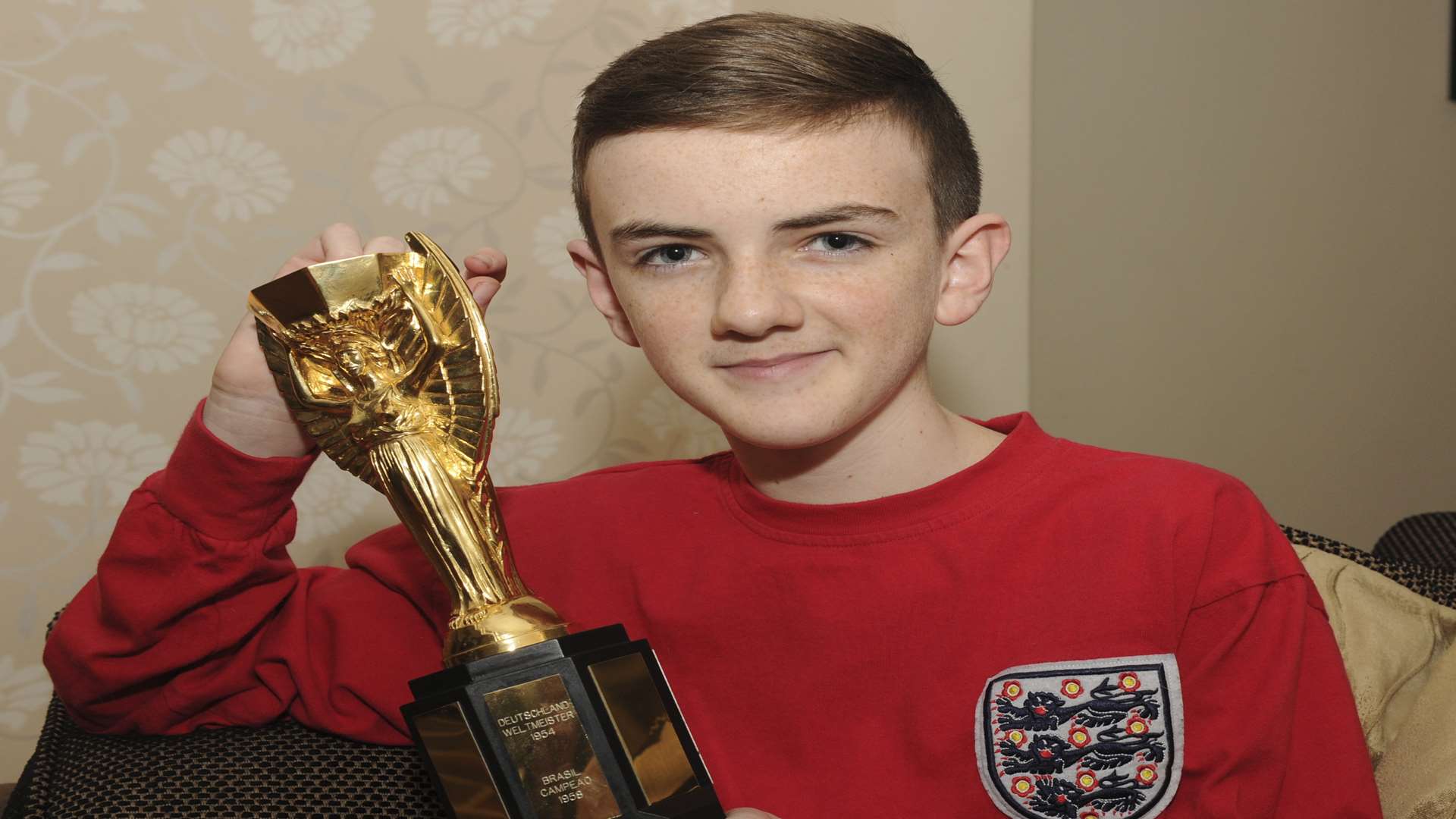 Jonjo Heuerman is the youngest person to receive the British Empire Medal. With replica Jules Rimet World Cup football trophy. Picture: Steve Crispe