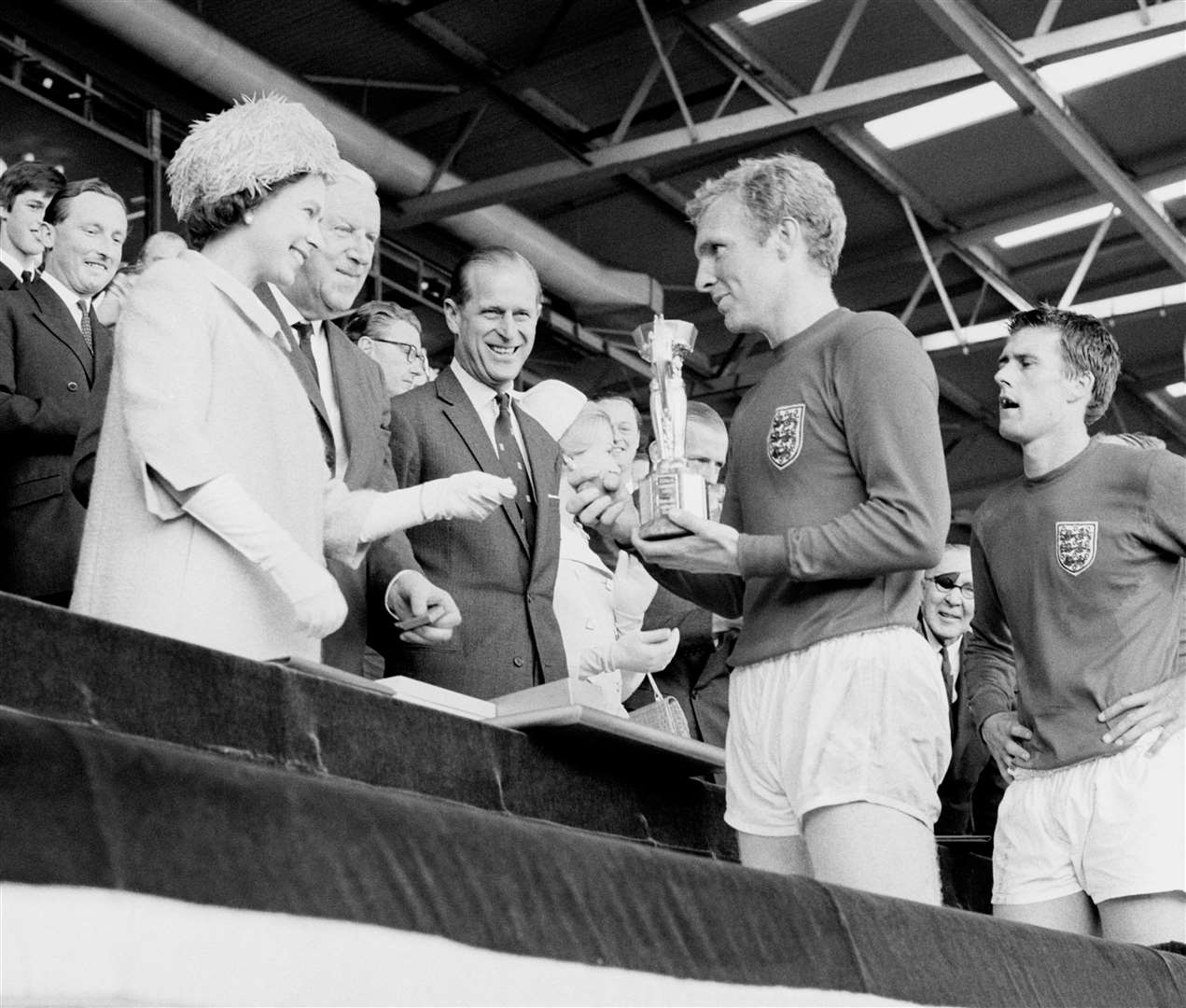 England captain Bobby Moore holds the Jules Rimet Trophy, collected from the Queen, after England’s 1966 World Cup win (PA)